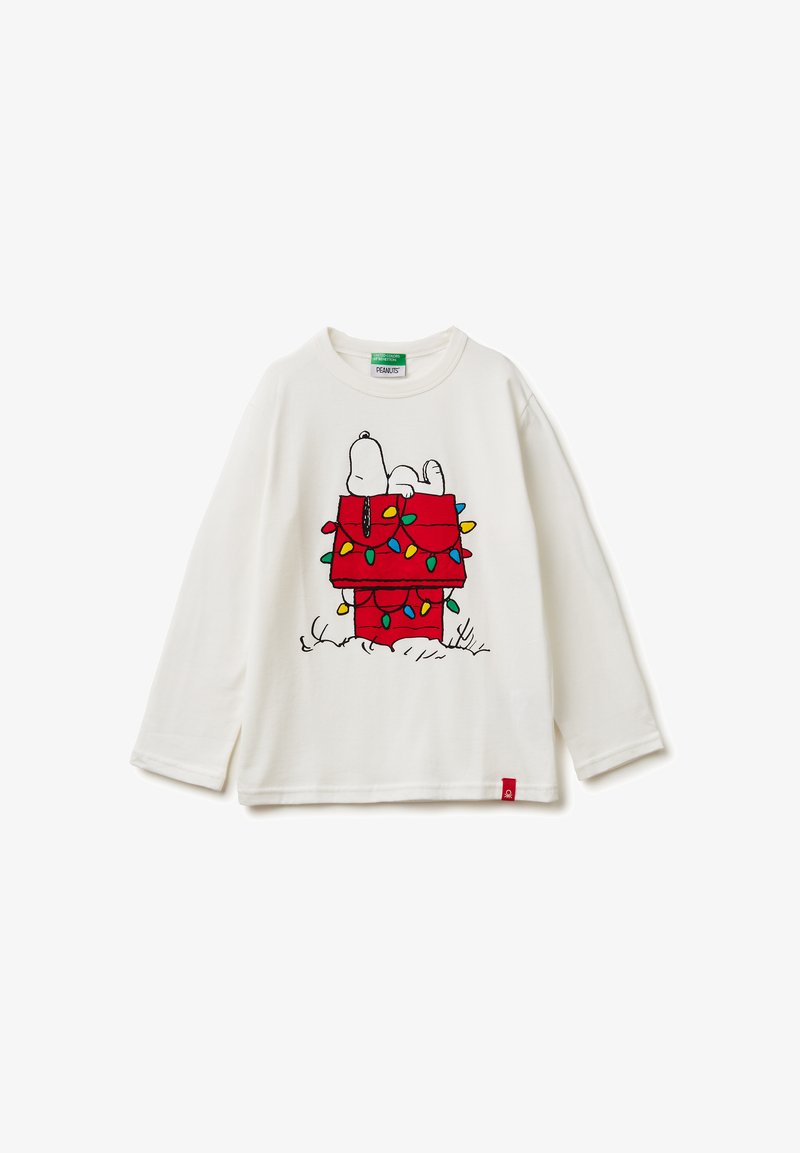 Biała koszula z długim rękawem z grafiką Snoopiego na czerwonym domku dla psa ozdobionym kolorowymi światełkami bożonarodzeniowymi. Czerwona metka przy dolnym brzegu.