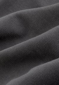 Tessuto grigio scuro con una texture liscia, caratterizzato da sottili motivi a trama fine e un dettaglio superficiale morbido e drappeggiato.