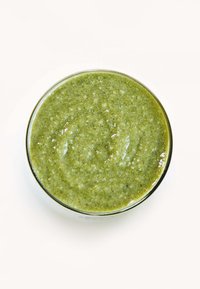 Groene smoothie in een heldere glazen kom. Soepele, dikke textuur met een levendige groene kleur en een lichte glans, getopt met een glad oppervlak.