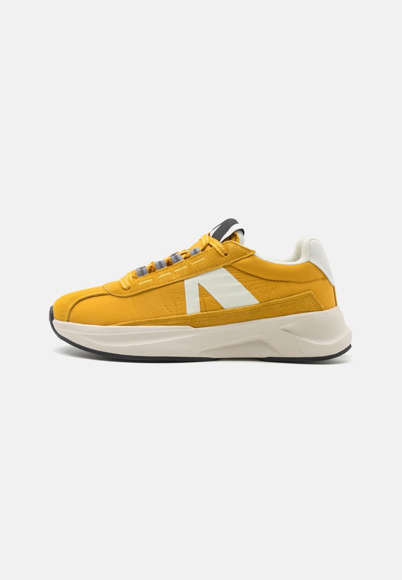 Yellow athletic sneaker with a smooth texture, featuring a white logo, gray laces, and a cushioned sole contrasting a black outsole.
