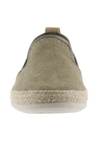 Zapato slip-on de lona beige con paneles laterales elásticos, parte superior texturizada y suela envuelta en yute. Diseño minimalista con punta redondeada.