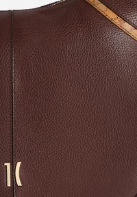 Borsa in pelle marrone con texture granulosa, cuciture verticali e tracolla decorata con motivo a mappa. Dettagli in metallo dorato inclusi.