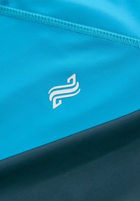 Tessuto atletico azzurro chiaro con accenti blu scuro, caratterizzato da un design del logo bianco; texture liscia e bordi cuciti.