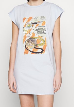 Biała sukienka bez rękawów z kolorowym szkicem ukazującym nakrycie stołu z kieliszkiem do wina, talerzem z jedzeniem i zegarkiem na nadgarstku.