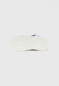 White sneaker sole with circular and hexagonal tread patterns, purple upper visible at the top, displayed on a plain white background.