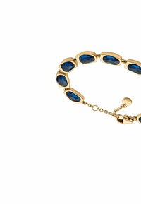 Guldtonat armband med blå ovalformade stenar, satta i en mjuk, böjd design, med en lås och justerbar kedja för anpassning.