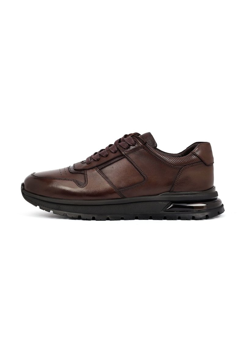 Bruine leren sneaker met een ronde neus, gepadde tong en vetersluiting aan de voorkant. Heeft textuur aan de zijkanten, een gevoerde zool en contrasterende zwarte accenten.