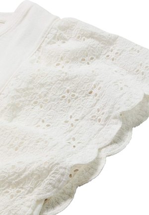 Weißer Stoff mit floraler Lochstickerei und gezackten Kanten, zeigt zarte Spitzenstruktur und weiches Baumwollmaterial.