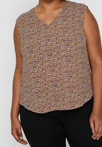 Kwiatowy bezrękawnik z dekoltem w kształcie litery V, na beżowym tle w fioletowe, żółte i różowe wzory. Materiał jest lekki i teksturowany.