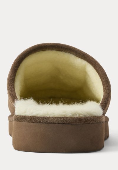 Bruine pantoffel met dikke witte fleecevoering, getoond vanaf de hielopening tegen een effen witte achtergrond.