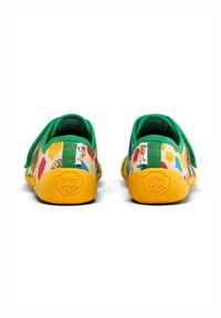 Scarpecolorate per bambini con tomaia in tessuto decorata con motivi di animali, dettagli in tessuto verde e suola in gomma gialla.