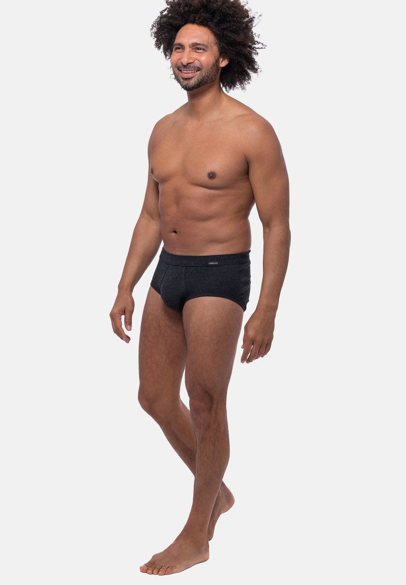 Schwarz gestreifte Unterhose mit einem weichen Gummibund, aus dehnbarem Stoff gefertigt. Das Design zeichnet sich durch eine figurbetonte Form und minimalen Markenaufdruck auf der Vorderseite aus.