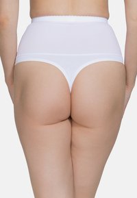 Tanga bianco a vita alta con cinturino ondulato e texture liscia. Mostra un primo piano del design e della vestibilità sul retro.
