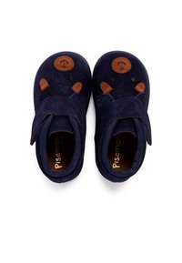 Scarpe in suede blu navy con una cintura in velcro, dotate di dettagli marroni e un logo rotondo sulla punta. Texture morbida, progettate per il comfort.