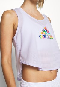 Hellviolettes ärmelloses Sportoberteil mit Netzstruktur und einem mehrfarbigen Adidas-Logo auf der Brust. Cropped-Design, lockere Passform.