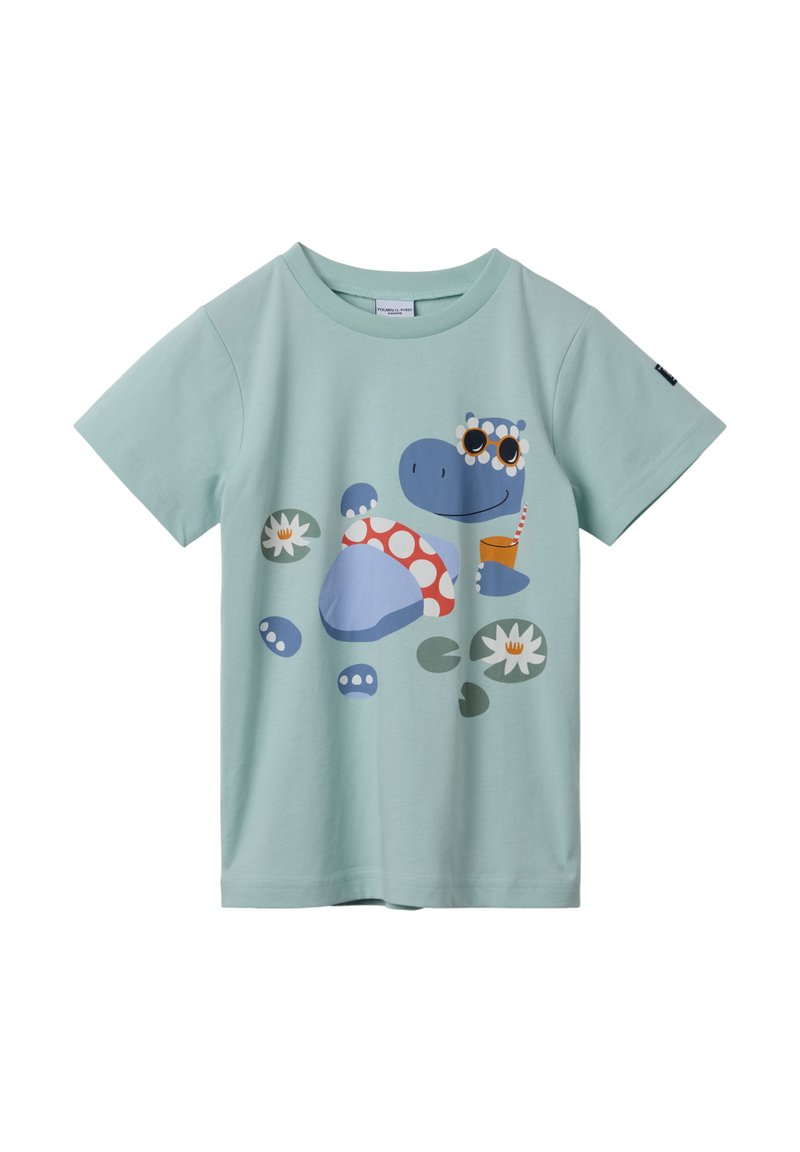 Vaaleansininen puuvillapaita, jossa on piirretty hippo, jolla on aurinkolasit, punaisia pilkkuja ja vesililjoja. Lyhyet hihat ja pyöreä kaula-aukko.