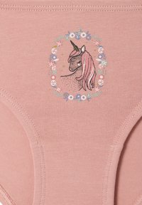 Einhornkopf mit rosa Mähne in einem kreisförmigen Blumenkranz auf einem rosafarbenen Stoffhintergrund.