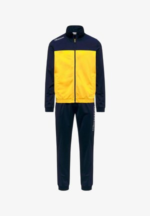 Veste zippée bleu marine et jaune avec pantalon bleu marine assorti, poignets élastiques et logos Kappa sur l'épaule de la veste et sur la jambe du pantalon.