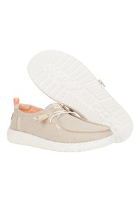 Scarpe slip-on in tela beige con suola in gomma bianca maculata, lacci elastici e un motivo interno arancione a contrasto.