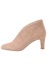 Beige suède enkellaars met een spitse neus, een gladde textuur en een bescheiden hak. Kenmerkt zich door een slank ontwerp met minimale stikdetails.