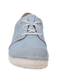 Chaussure en cuir bleu clair avec des coutures discrètes, bout arrondi, lacets blancs et semelle texturée. Présente un petit accent en métal près des lacets.