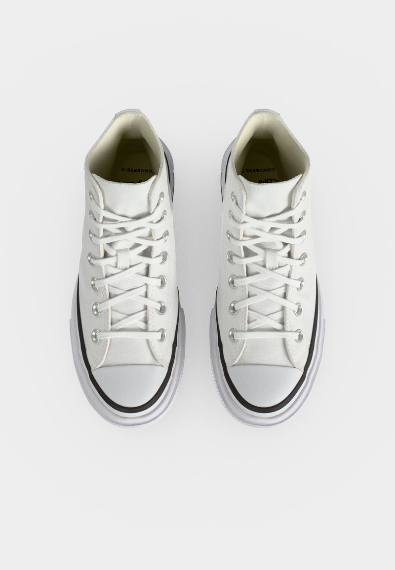 Paio di Converse alte bianche con lacci bianchi e dettagli neri, viste dall'alto su uno sfondo bianco semplice.