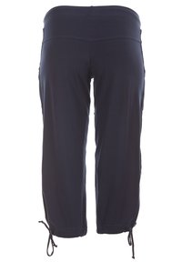 Námořnické modré zkrácené kalhoty s širokým elastickým páskem, nařasenými manžetami s tkaničkami a bez viditelných kapes. Hladká textura látky.