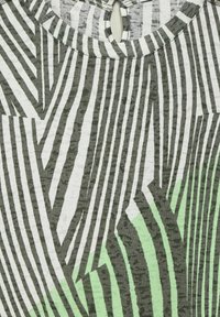 Kurze Ärmel Bluse mit einem geometrischen Muster aus grünen und dunkelgrauen Streifen auf weißem Hintergrund, mit rundem Halsausschnitt und Schlüsselloch-Detail.