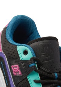Black sneaker with mesh and leather materials. Features turquoise, pink, and purple accents. Textured fabric and logo detail visible.