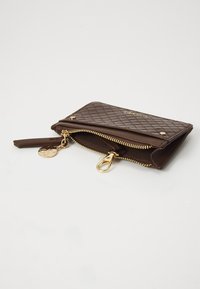 Brown quilted wallet with gold zip and hardware. Features a detachable keychain and a textured surface with a zipper closure.