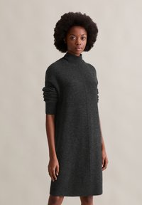 Dunkelgraues Rollkragenkleid aus weicher Stoffqualität, mit fallenden Schultern, umgeschlagenen Bündchen und einer knielangen Silhouette mit geradem Schnitt.