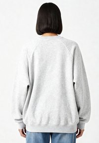 Sweat-shirt gris en tissu doux et texturé. Comprend des manches raglan, un col rond et une coupe décontractée. Poignets et ourlet côtelés.