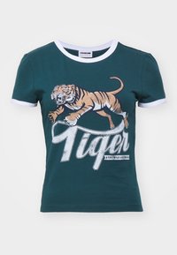 Camiseta de algodón color aguamarina con escote redondo, con ribete en blanco, que presenta un gran gráfico de un tigre saltando y la palabra "Tiger."