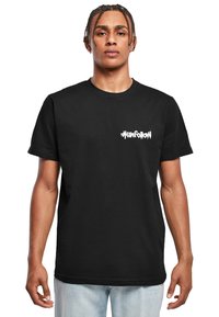 Černé triko s krátkým rukávem vyrobené z bavlny, se bílou grafikou hashtagu "#unfollow" umístěnou na levé straně hrudi. Klasický design s kulatým výstřihem.