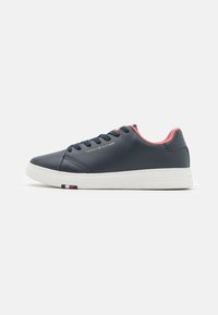 Sneaker in pelle blu navy con suola bianca, dettagli rosa e strisce nera, bianca e rossa sul tallone. Presenta sei fori per i lacci e dettagli di branding.