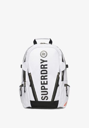 Hvid rygsæk med sorte detaljer og lynlåse. Har stort "SUPERDRY"-tekst, logo og to sidelommer. Lavet af holdbart materiale.