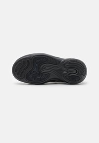 Svart sneaker sula med ett vågigt mönster och texturerad yta med en logotyp-impresion. Designad för grepp och stabilitet.