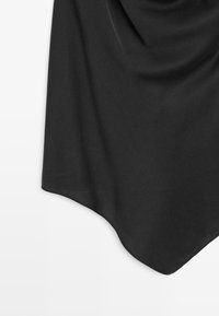 Tessuto nero con una texture liscia, che drappeggia in modo elegante. Presenta un bordo curvo e morbide pieghe, adatto per essere sovrapposto o come pezzo a sé stante.