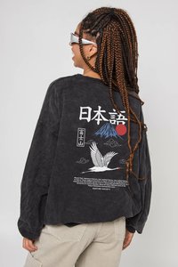 Fekete kapucnis felső, amelyen egy nagy grafikai tervezés látható a Fuji-heggyel, egy piros nappal és egy daruval. Japán szöveg a hátsó részén, laza fazon, hosszú ujjú.