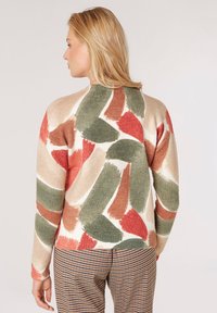 Maglione a maglia con un motivo astratto multicolore nei toni del verde, rosso e beige. Collo rotondo, maniche lunghe e dettagli a costine sull'orlo.