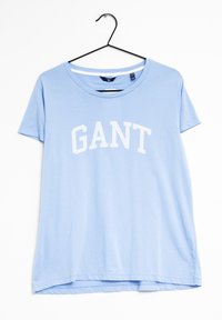Ljusblå kortärmad T-shirt med en vit "GANT"-logotyp över bröstet. Tillverkad av mjukt material, med rundad halsringning och avslappnad passform.