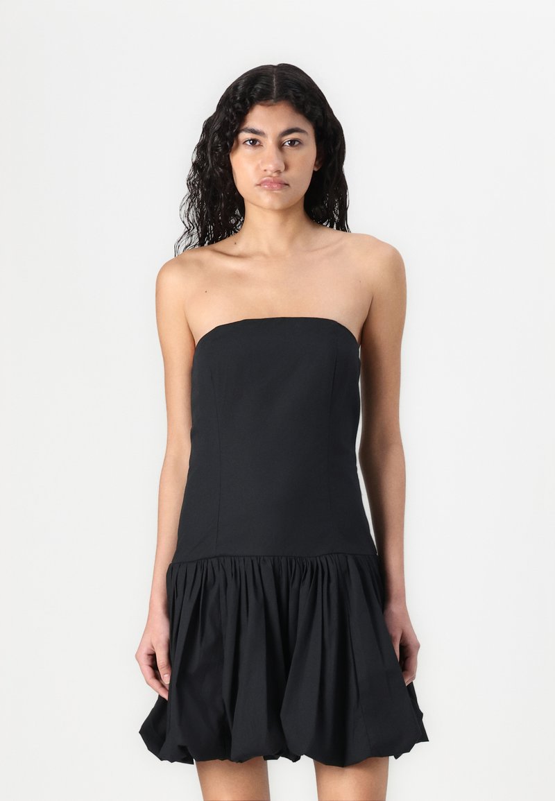 Robe noire sans bretelles avec un corsage ajusté et une jupe évasée froncée. Fabriquée dans un tissu lisse avec une finition mate.