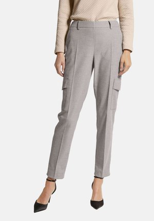 Grijze wolmix broek met een getailleerde pasvorm, een vlakke voorkant, twee cargozakken en taps toelopende pijpen, gecombineerd met zwarte puntige hakken.