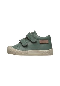 Chaussure en cuir vert avec deux bandes Velcro, semelle en caoutchouc crème, capuchon de bout texturé et un patch de marque sur le côté extérieur.