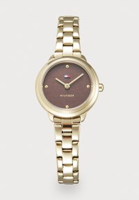 Gold-tone metal watch with a round case and brown textured dial. Features three gold hands and small gold hour markers. Bracelet-style band.