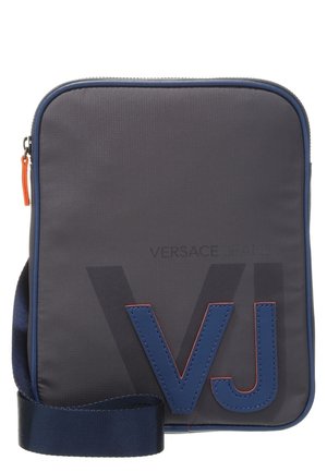 Sacoche en bandoulière compacte de couleur gris foncé avec des finitions bleu marine, une large sangle réglable et de grandes lettres "VJ" bleues à l'avant.