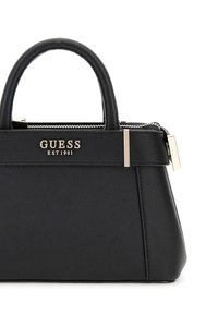 Borsa nera sintetica con un design strutturato, manici corti, hardware argentato e chiusura con zip. Logo "GUESS EST 1981" sul fronte.