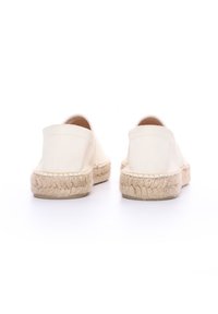 Espadrilles de lona en color blanco roto, con suela de cuerda de yute y sin marcas visibles, diseñadas para poner y quitar fácilmente y con comodidad.