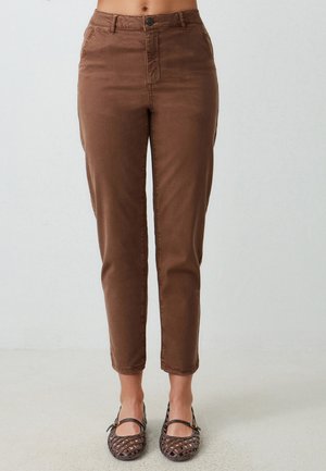 Bruine katoenen broek met een slim fit, voorzakken en een knoopsluiting, eindigend boven de enkel. Gepaard met geweven bruine ballerina's.