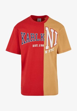 Piros és aranysárga, rövid ujjú póló; kiemelkedő felirattal "KARL K" és "NI NYC" kontrasztos színekkel és laza szabással.